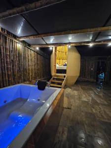 a large bath tub in a room with a bed at Parador La Mesa Redonda Hotel y Glamping in Los Santos