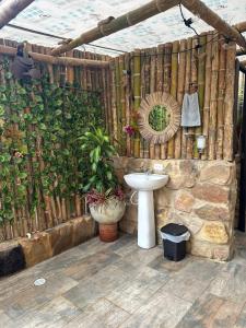 baño con lavabo y pared con plantas en Parador La Mesa Redonda Hotel y Glamping, en Los Santos