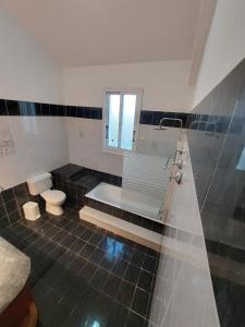 a bathroom with a tub and a toilet and a sink at Villa Agios Georgios with Private Pool in Peyia