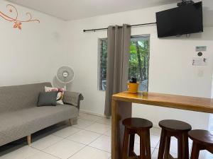 a living room with a couch and a table and stools at Villas Majolana in Herradura