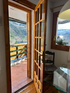 a door to a balcony with a view of the mountains at ASPEN - 6 pax, garaje, a 5 min pistas esqui Formigal in Sallent de Gállego