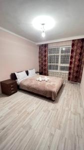 a bedroom with a large bed and a window at 3 комнатная квартира Бесагаш Сити in Almaty