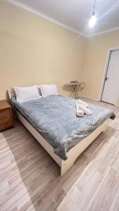 a bedroom with a bed in a room with a table at 3 комнатная квартира Бесагаш Сити in Almaty