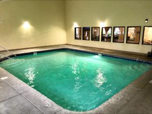 a large swimming pool with green water in a room at Quality Inn Selah North Park in Selah
