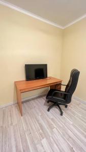 a computer desk with a monitor and a black chair at 3 комнатная квартира Бесагаш Сити in Almaty