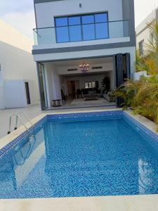 a large swimming pool in front of a house at Oceanfront Villa 5BHK with private pool and seaview in Fujairah
