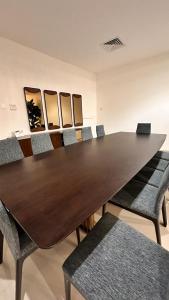 a conference room with a long wooden table and chairs at Oceanfront Villa 5BHK with private pool and seaview in Fujairah