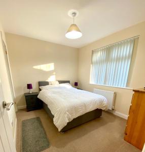 a bedroom with a large bed and a window at Eden Stay in Morecambe
