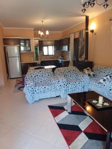 - un salon avec trois lits et une table dans l'établissement Leonidas Apartment, à Berat