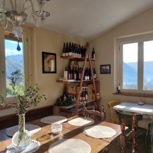 a dining room with a table and a shelf of wine bottles at Agriturismo Tenuta La Fratta in Bagni di Lucca