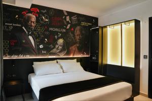 a bedroom with a bed with a poster on the wall at SO City Hotel Adults Only in St. Julianʼs