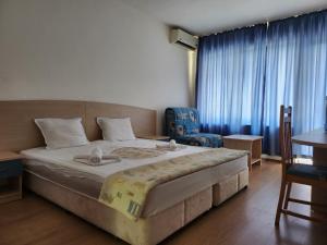 une chambre avec un grand lit et une chaise dans l'établissement park-hotel Rusalka, à Varna
