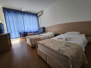 une chambre d'hôtel avec deux lits et une télévision dans l'établissement park-hotel Rusalka, à Varna