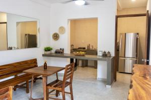 a kitchen with a dining table and a kitchen with a refrigerator at Casa Ita Surf - Adults Only in Puerto Escondido