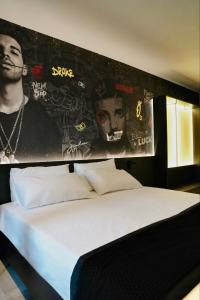 a bedroom with a bed with posters on the wall at SO City Hotel Adults Only in St. Julianʼs