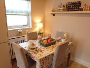 una mesa de comedor con una cesta de fruta. en Lovely room with ensuite in a quiet house en Rayleigh