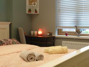 a bedroom with a bed with towels on it at Lovely room with ensuite in a quiet house in Rayleigh