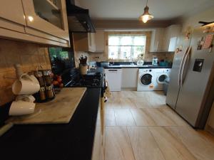 a kitchen with a stove and a refrigerator at Lovely room with ensuite in a quiet house in Rayleigh