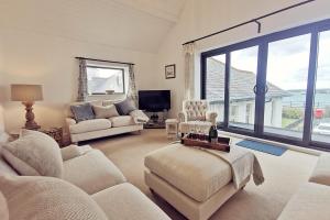 a living room with white furniture and a large window at TULLOCHSIDE-4 BED-SEA FRONT -RAVENSPOINT ROAD in Trearddur