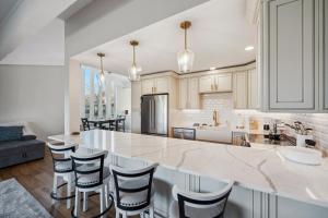 a kitchen with a large white counter and chairs at Elegant 4-Season Lake Geneva Condo with Fireplace! in Lake Geneva