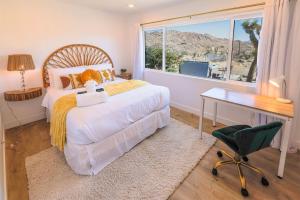 a bedroom with a bed and a desk and a window at New: Dome, Hot Tub, Game Room, 5 min to park in Joshua Tree