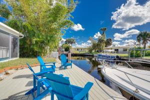 eine Terrasse mit blauen Stühlen und einem Boot in der Unterkunft North Fort Myers Home with Hot Tub and Boat Dock in North Fort Myers