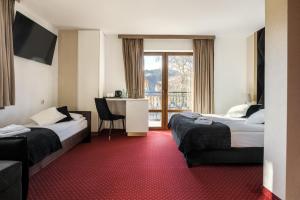 コシチェリスコにあるDworek pod Giewontemのベッド2台と窓が備わるホテルルームです。