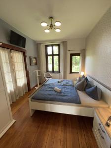 Schlafzimmer mit einem großen Bett mit blauer Decke in der Unterkunft Villa Lattermann in Muldenhammer