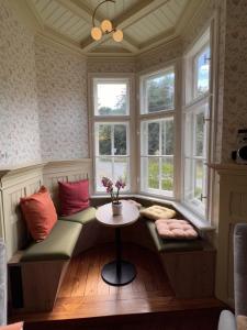 un posto a sedere vicino alla finestra in una stanza con tavolo di Villa Lattermann a Muldenhammer