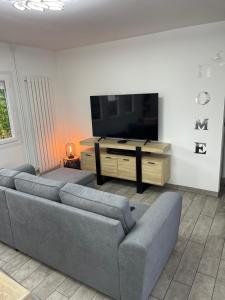 a living room with a couch and a flat screen tv at Maison plain pied a Dieppe in Dieppe