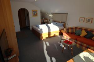 een woonkamer met een bed en een bank bij Ferienwohnung Blüm - b46150 in Mittenwald