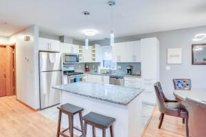 a kitchen with white cabinets and a table and chairs at Lovely Minneapolis Home Near Target Field! in Minneapolis