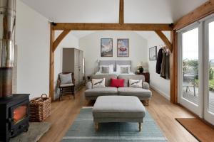 un soggiorno con divano e camino di Stunning Cabin with incredible views near Goodwood a Rogate