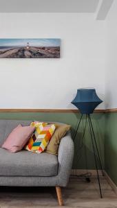 une lampe assise à côté d'un canapé dans une pièce dans l'établissement Charmant appartement proche de l’Abbaye-aux-dames, à Caen