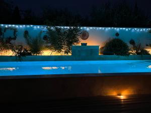 una piscina iluminada por la noche con luces en Les Logis de Cocagne, en Saint-Rémy-de-Provence