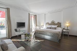 a white bedroom with a bed and a couch at Hospes Puerta de Alcalá, a Member of Design Hotels in Madrid