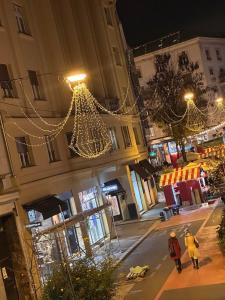 two people walking down a street at night with christmas lights at Rooms Gollner in Zagreb