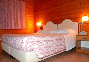 una camera con un letto bianco e una parete in legno di Agriturismo "Gli Olmi" a Corropoli