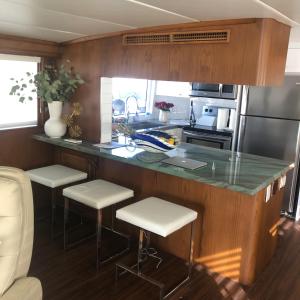 a kitchen with a counter and stools in a kitchen at Luxury Afloat Yacht Paradise 3 bedrooms 3bath 5 beds with full Marina view in Los Angeles