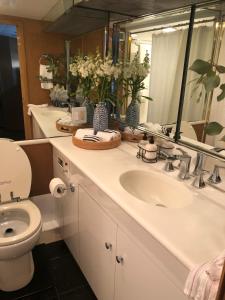 a bathroom with a sink and a toilet and a mirror at Luxury Afloat Yacht Paradise 3 bedrooms 3bath 5 beds with full Marina view in Los Angeles