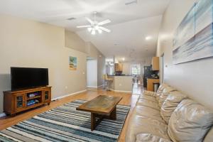 a living room with a couch and a flat screen tv at Pet-Friendly Cape Coral Retreat with Screened Porch! in Cape Coral