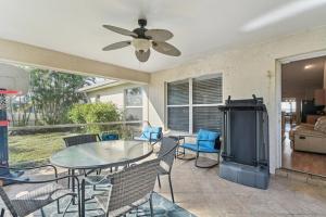 a patio with a table and chairs and a ceiling fan at Pet-Friendly Cape Coral Retreat with Screened Porch! in Cape Coral