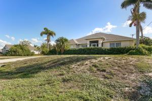 a house on a hill with palm trees at Pet-Friendly Cape Coral Retreat with Screened Porch! in Cape Coral