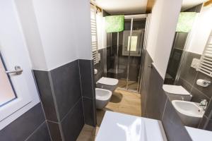 bagno con 2 servizi igienici, lavandino e doccia di Savenella house a Bologna