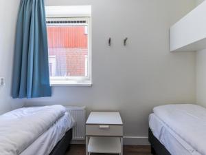 2 Betten in einem kleinen Zimmer mit Fenster in der Unterkunft Great Assum in Uitgeest