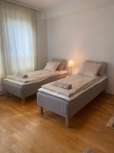 2 łóżka pojedyncze w pokoju z drewnianą podłogą w obiekcie Parvekkeellinen moderni asunto w mieście Turku
