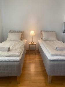 dwa łóżka w pokoju z lampką na stole w obiekcie Parvekkeellinen moderni asunto w mieście Turku