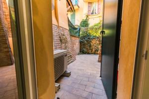 una porta aperta su un cortile con muro di mattoni di Savenella house a Bologna