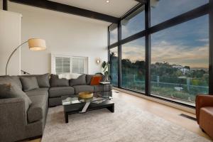 a living room with a couch and a large window at Luxury Hollywood Hills Gated VIEW estate - ultra private and gorgeous! MINUTES TO UNIVERSAL STUDIOS AND HOLLYWOOD! in Los Angeles