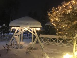 a gazebo covered in snow at night with lights at Aurora Center 3 in Rovaniemi